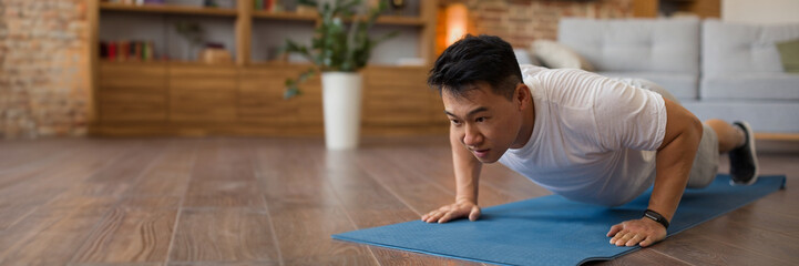 Wall Mural - Strong asian mature man making strength workout at home