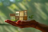 Fototapeta Do akwarium - Hand holding a miniature house model, property and investment concept.