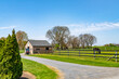 Sunny day in Amish country with a horse grazing behind a wooden fence near a barn and buggy in Lancaster, Pennsylvania, showcasing peaceful farm life. High quality photo. Lancaster, PA, USA