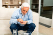Middle aged senior man with medical pill and glass of water. Mature old senior grandfather taking medication cure pills vitamin. Age prescription medicine healthcare therapy concept