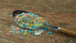 Microplastics in a spoon. A concept of consuming micro plastic particles, water and soil pollution.
