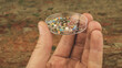 Close up shot of man holding a lab petri dish with microplastic particles. Concept of plastic pollution with nanoplastics. Detail of micro plastic particles that cannot be recycled.