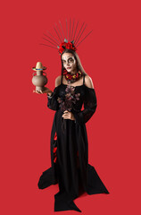 Wall Mural - Young woman with painted skull on her face, sombrero and vase against red background. Celebration of Mexico's Day of the Dead (El Dia de Muertos)