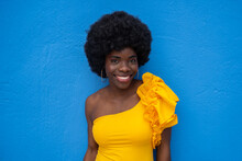 Smiling Woman In Yellow With Blue Backdrop