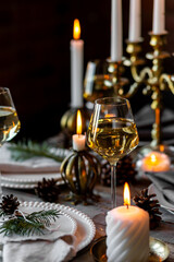 Wall Mural - Rustic elegant table decor for christmas family dinner. Center piece with white candle, pine cone, fir tree branches. Zero waste eco-friendly home decoration. Cozy atmosphere, wooden background.