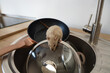 Little rat on frying pan in sink, closeup. Pest control concept