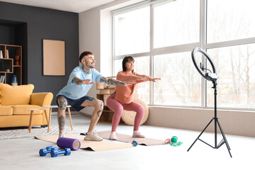 Wall Mural - Couple of sports bloggers recording training video at home