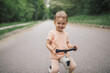 Smiling toddler girl posing on push scooter