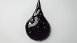 a single, large black liquid droplet adorned with tiny bubbles. The droplet’s teardrop shape suggests it is either suspended or falling