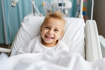 A young boy's resilient spirit shines through with a bright smile as he rests in a hospital bed, providing a heartwarming moment of joy in a clinical setting.