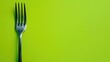 Metal fork against lime green background with ample space