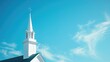 White church steeple against blue sky with wispy clouds