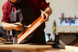 Carpenter applying wax on wooden surface to prevent damage and provide layer of protection. Woodworking expert in assembly shop doing finishing on wood plank, putting coats of oil