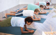 Young children does yoga on mat in yoga class. Peaceful kids standing in plank on elbows. Healty lifestyle. Sampattasana pose.
