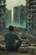 A man sits on the ground in front of a city reduced to rubble, looking sadly at his surroundings.