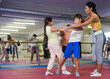 © JackF - Teenage boys and girls in pairs practicing self-protection during group class at gym