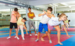 © JackF - Focused kids in pair exercising self-defense movements during group class with female coach