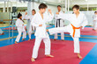 © JackF - Pair of teenager boys wearing kimono practicing new karate moves during training in gym