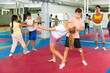 © JackF - Kids learning self-defence moves during group training. Trainer standing beside and observing.