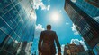 © Barosanu - Attractive young man entrepreneur walking alone on the street low angle portrait next to skyscraper