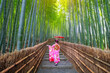 Bamboo forest. Japanese girl wearing a traditional Japanese kimono at the bamboo forest in Kyoto, Japan.