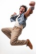 Energetic young man with curly hair leaps high, celebrating with a thrilled expression against a white background.