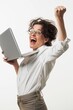 Joyful woman with glasses holding a laptop and cheering with a fist pump against a white background.