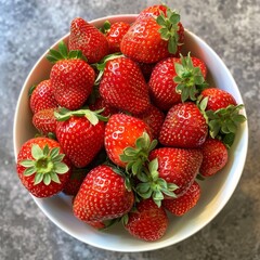 Sticker - Luscious strawberries fill a white bowl from a top-down perspective, showcased on a grey countertop