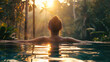 A woman relaxing in an infinity pool enjoying the natural scenery of lush greenery and trees at sunset, feeling calm after her spa experience