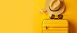 A yellow suitcase with a sun hat and sunglasses on a yellow background. A travel concept in a minimalist aesthetic.