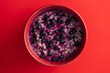 Oatmeal porridge with ripe blueberries for healthy breakfast on red background, closeup, top view