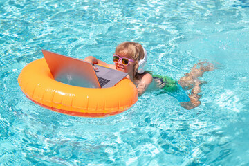 Wall Mural - Summer business. Kid working on laptop computer at poolside swimming pool. Summer online technology. Traveler relaxing on tropical sea in summer holidays.