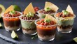 Seven layer dip in individual cups, mexican appetizer with refried beans, salsa, guacamole