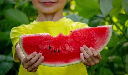 Wall Mural - a boy eats a delicious piece of watermelon in the summer.