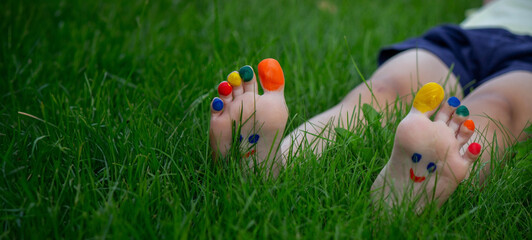 Wall Mural - a smile drawn with paints on a child's legs