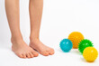 colored needle balls for massage and physiotherapy on a white background with the image of children's feet, the concept of prevention and treatment of hallux valgus