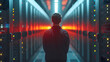 A technician stands at the end of an aisle in a data center, surrounded by servers with glowing red lights, overseeing the complex network infrastructure that powers modern computing.