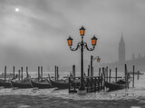 Fototapeta Sawanna - Gondolas in Venice at sunrise in morning fog. Veneto, Italy..