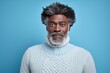 Portrait of a merry afro-american man in his 50s showing off a thermal merino wool top isolated on pastel blue background