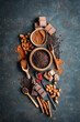 Schokolade, Nüsse und rote Pefferkörner auf einem dunklen Hintegrund. Rustikaler Stil, Draufsicht.