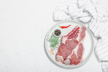 Wall Mural - Raw pork neck meat. Chop steak, red peppercorn, garlic cloves, sea salt and fresh rosemary