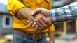 © S-Rika - Renovation Agreement with Homeowner Giving Handshake with Contractor Blurred Background