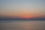 Fototapeta Przestrzenne - warm red sun at the horizon at the sea shortly after sunrise