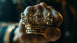 An image of a man's fist with a golden crown.