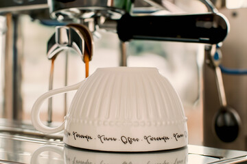 Wall Mural - A porcelain cup on the table next to the coffee machine.