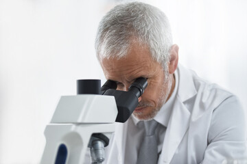 Poster - Scientist, mature man and microscope in lab for discovery, medical research and test for forensics. Male person, analyze and doctor for biology or pathology exam, lens and check results of experiment