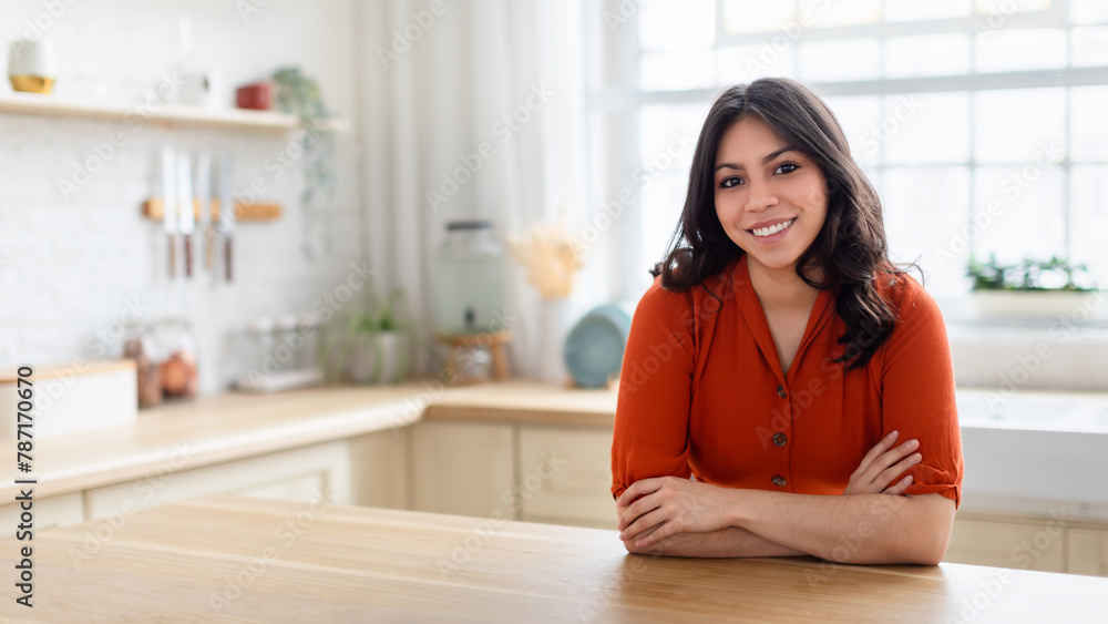 Smiling woman in orange blouse at home