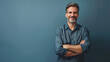 © Generative AI - Handsome middleaged man standing with his arms folded looking at camera and smiling Halflength front portrait against blue background with copy space : Generative AI