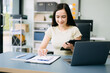© Nuttapong punna - Asian businesswoman typing laptop and tablet Placed at the table at the office.