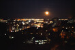 Defocused photograph of Moon over night city